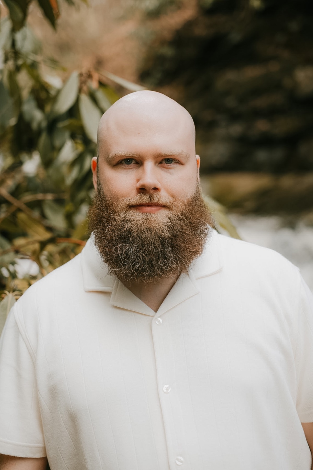 Nate Lain in a white shirt, photographed among green plants
